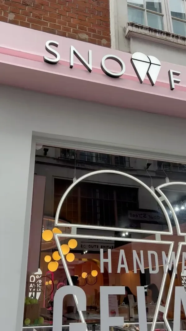 The video showcases Snowflake Gelato in Soho, London. It highlights their Iced Pistachio Latte, Lotus Biscoff Sundae Shake, and Gelato baskets with praline, salted caramel, and Kinder gelato.  The presentation emphasizes the visually appealing colors and textures of the desserts and drinks.  No specific dietary information is provided. The main focus is on showcasing the food and drink offerings and the pleasant atmosphere of the cafe.