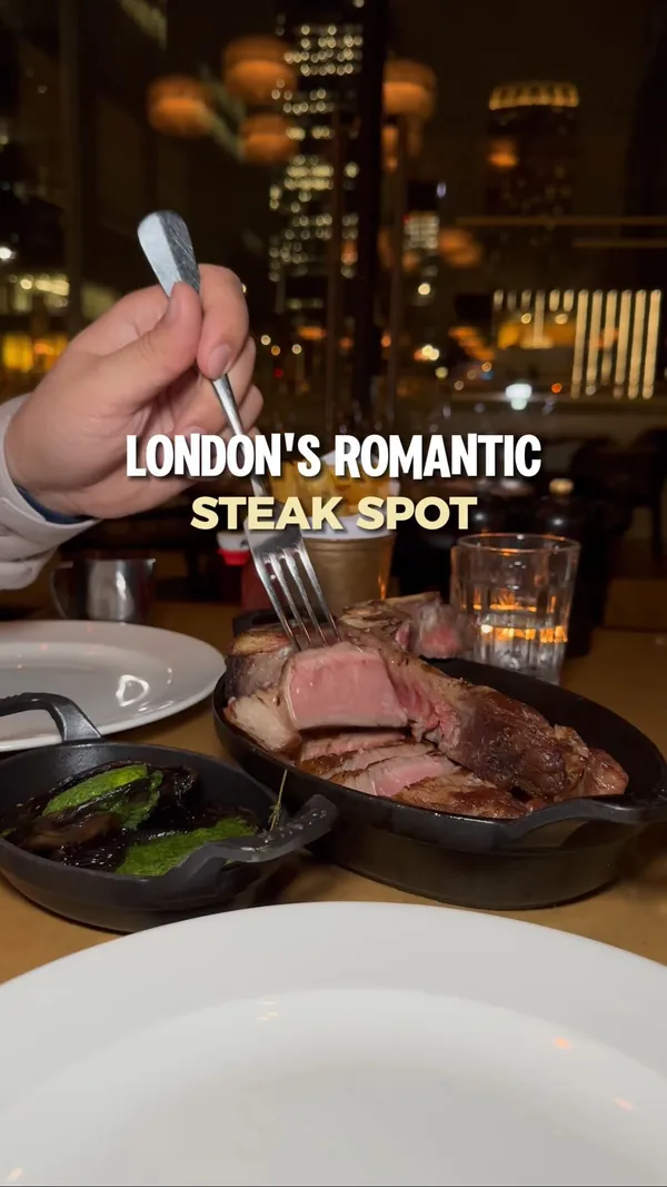 This video showcases a romantic dinner at Hawksmoor in Canary Wharf, London.  The video highlights the restaurant's ambiance, stunning views, and food, including a Porterhouse steak, oysters, scallops, and desserts like a hot chocolate tart. The food is presented beautifully, emphasizing its high quality and visual appeal.  No specific dietary information is given.