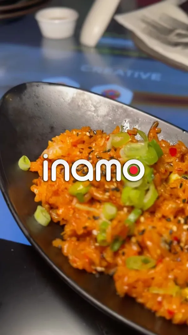 This video showcases a dining experience at Inamo restaurant in London. The setting is modern and stylish, with interactive tables and a drag show.  Various dishes are shown, including sushi, fried chicken, gyoza, and rice dishes.  The food presentation is sleek and visually appealing, utilizing black plates and bowls. No dietary information is explicitly provided. The video primarily focuses on the vibrant atmosphere and delicious food of the restaurant.