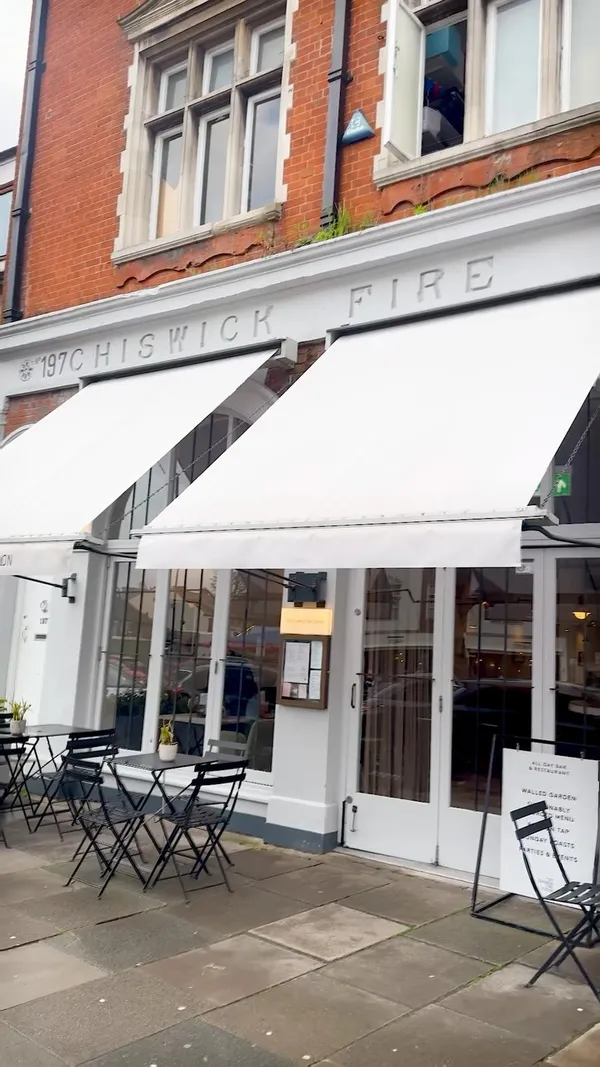 The video showcases No197 Chiswick Fire Station, a restaurant in Chiswick, London. It highlights their happy hour deals (5pm-7pm) and food items such as crispy squid with chili jam and coriander, the house burger, and various cocktails including Picante, Bloody Mary, Pineapple Apricot Gimlet and Tropical Island. The video features shots of the restaurant's interior and exterior, highlighting its ambiance. Food items are presented attractively, with close-ups emphasizing texture and details.