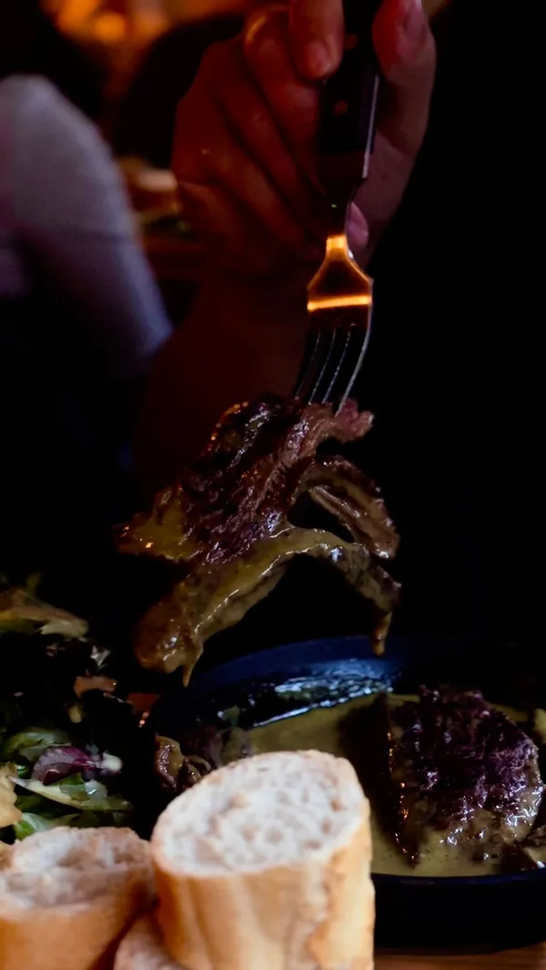 This video showcases Swiss Butter, a halal steakhouse in London, known for its £19 steak platters. The video highlights the restaurant's ambiance, the plating of the food (two steak platters, each with fries, bread, salad, and a unique sauce), and its desserts (bread butter pudding and chocolate lava cake). The unique sauce is emphasized as being made of 33 herbs and butter. The primary focus is showcasing the food and the restaurant's atmosphere.