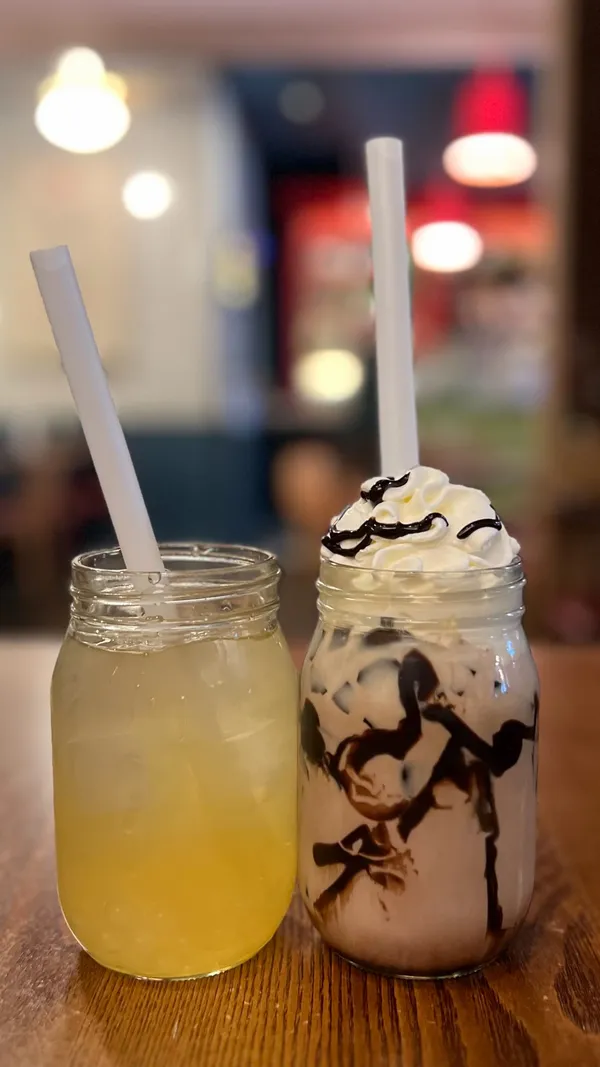 The video features two influencers visiting Rosa's Thai restaurant to celebrate Songkran. They showcase the restaurant's exterior and interior, highlighting the decor and atmosphere. They order and try limited-edition bubble teas (jasmine and chocolate options) and a food dish (noodles) from the lunch menu. The video includes close-ups of the menus, drinks, and food. The influencers express positive reactions to the drinks. The video mentions Songkran festivities and the restaurant's lunch menu offer.