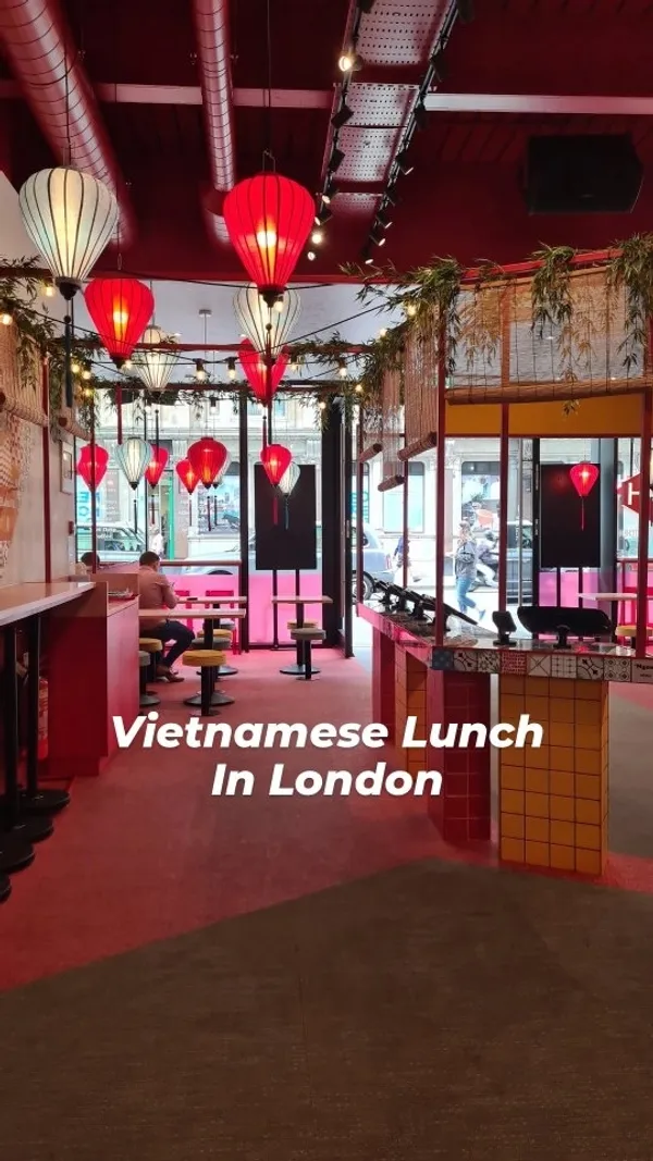 The video showcases Hop Vietnamese restaurant in London, focusing on their various dishes.  It features a quick exterior shot of the restaurant's location, then moves to close-up shots of different food items: a curry noodle soup, a peanut chicken dish with rice and fried onions, a banh mi sandwich, dumplings with a dipping sauce, and a chicken rice noodle dish. The video also includes shots of the restaurant's interior and some canned juices. The presentation of the food is appealing and focuses on the visual aspects and colors.