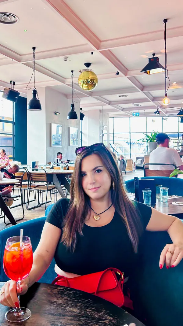 The video showcases a day in the life of an influencer in London, featuring various food and drink establishments. It begins with a morning coffee at home, transitions to brunch at a cafe, and then shows cocktails and food at a bar or restaurant with a view of the Battersea Power Station.  Specific food items shown include a latte, corn fritters with a sauce and smoked salmon, avocado toast, and Aperol Spritz. The presentation of the food is visually appealing, with focus on color and composition. No specific dietary information is provided other than a mention of gluten-free in the hashtags. The primary focus of the video is on the influencer's experience, and less about detailed food and drink promotion.