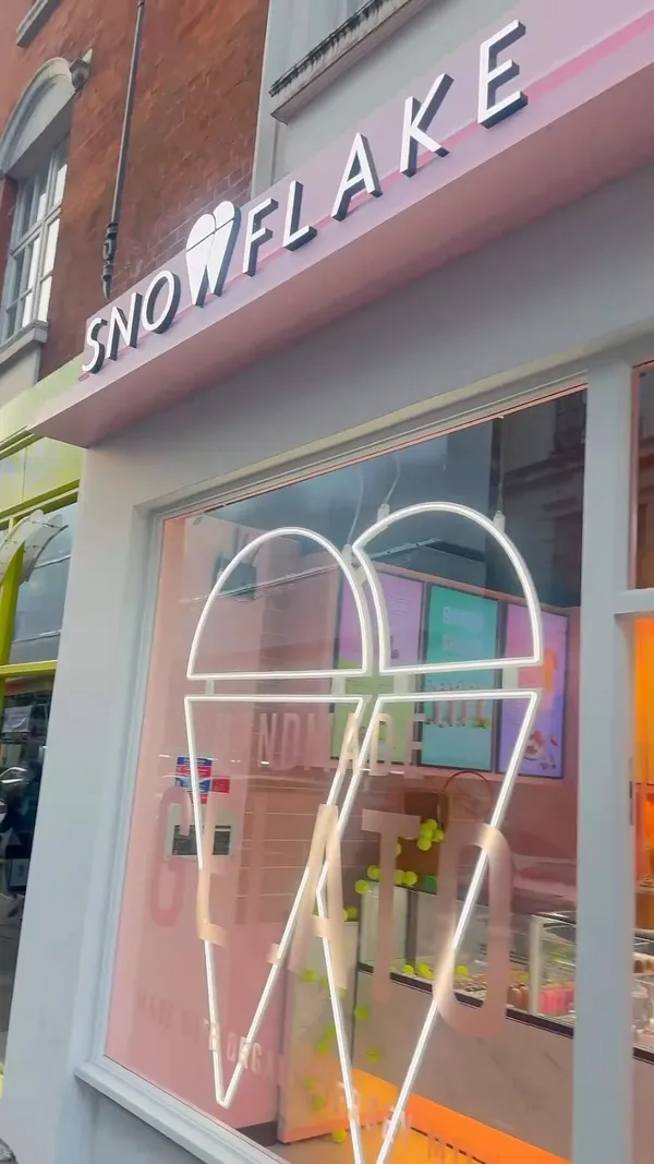 The video showcases Snowflake Gelato, a cafe in Soho, London. It highlights various menu items including the Wimbledon Special Iced Tennis Ball (strawberry and cream gelato), Gelato Basket Sicily (gelato with nuts and pistachio sauce), Sundae Shakes Strawberries and Cream, and Iced Pistachio Latte. The presentation focuses on close-ups of the desserts and drinks, emphasizing their vibrant colors and textures.  No dietary information is explicitly provided. The main focus is on showcasing the cafe's aesthetically pleasing desserts and drinks.