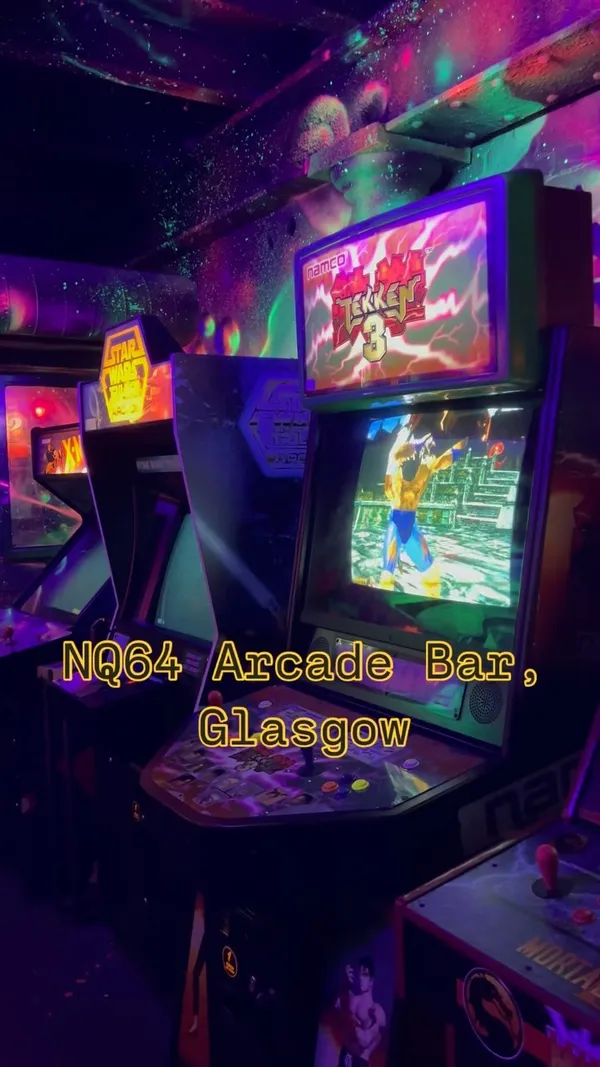 The video showcases NQ64, an arcade bar in Glasgow's Merchant City. It features various arcade games like Tekken 3, Guitar Hero, Dancing Stage, Mario Kart, and Crazy Taxi.  The drinks shown include a Paloma, a margarita, and another cocktail in a custom can. The bar's atmosphere is highlighted, showing neon lighting and unique decor. The main focus is showcasing the bar's ambiance and the fun of playing arcade games while enjoying drinks.