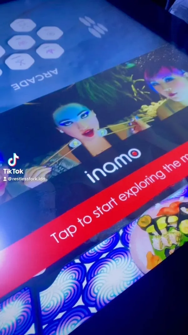 This video showcases Inamo Covent Garden, a restaurant with interactive gaming tables.  The video shows the ordering process via the table, various dishes (Miso Aubergine, Prawn Crackers, BBQ Pork Ribs, Soft Shell Crab Tempura, Yuzu Pork Belly, Soba Chicken Noodles, Spicy Duck with Pancakes, Chicken Karaage, various other dishes are briefly shown), wine being poured, and patrons playing games on the table.  The food is presented in visually appealing dishes. No specific dietary information is provided.