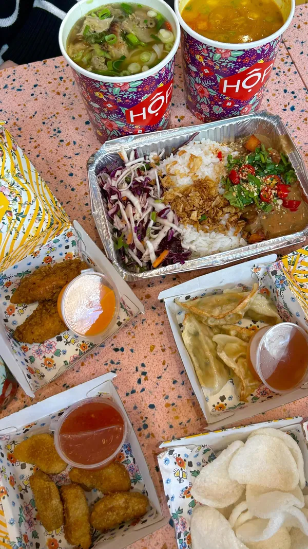 The video showcases Hop Vietnamese Kitchen, a restaurant in London.  It features various dishes, including the miso sweet potato satay HOP box, chicken pho, pulled mushroom coconut soup, prawn crackers, VFC dippers, hopcorn chick'n, and prawn dumplings.  The food is presented in visually appealing takeout containers.  Several vegan and vegetarian options are highlighted. The video mainly focuses on a meal showcase.