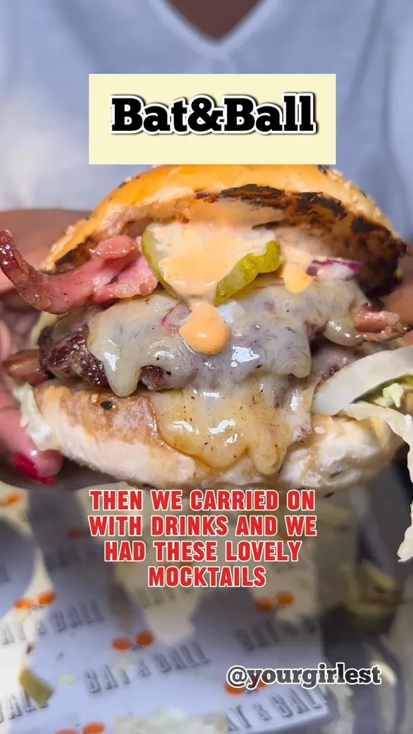 This video showcases a visit to Bat & Ball in Westfield Stratford, focusing on their new summer menu. The content includes various dishes, such as crispy squid, beef brisket tacos, Johnny Cash and Cowabunga burgers, raspberry and pistachio cheesecake, and a dark chocolate brownie. The drinks featured are a watermelon mocktail and a "Be My Lady" cocktail. The video emphasizes the food's presentation and taste, highlighting the juicy burgers and the warm brownie. The setting is the restaurant itself, with shots of the interior and menu.