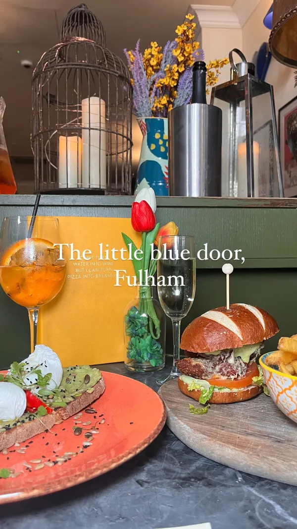 The video showcases The Little Blue Door in London, a cafe with a unique eclectic interior. It highlights their bottomless brunch menu, featuring items like a chicken burger with fries, poached eggs on avocado toast, and chocolate banana pancakes, accompanied by bottomless Prosecco, rum punch, or Aperol Spritz.  The food presentation is vibrant, focusing on close-up shots and an appealing color palette.