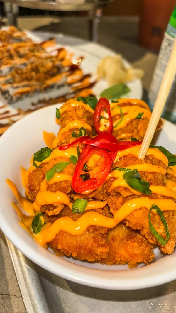 The video showcases a meal at Inamo restaurant in Oxford Circus, London.  The food includes a unique dragon roll sushi, crunchy salmon and avocado rolls, karaage chicken, and duck and pancakes. The presentation is visually appealing, with artistic arrangements and attention to detail. The video focuses on showcasing the various dishes and highlighting their visual appeal.