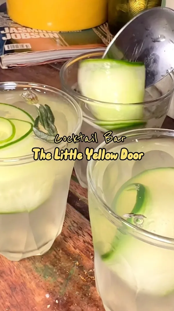 This video showcases The Little Yellow Door, a cocktail bar and restaurant in Notting Hill, London.  It features various cocktails, including a strawberry and cream infused vodka and passion fruit drink, and a cucumber and rosemary drink. The video highlights the bar's vibrant, eclectic atmosphere, its house-party style ambiance, and showcases different areas of the venue. The cocktails are presented in various glasses, and the video emphasizes the social aspect of enjoying drinks with friends.