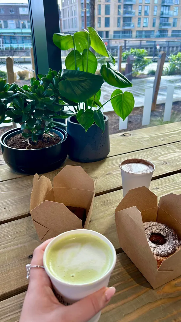 This video showcases a day out in Greenwich, London, visiting several food and drink establishments. It starts at The Coffee Studio, featuring matcha lattes and cronuts. Then it moves to Greenwich Market, highlighting various food stalls and the market's atmosphere. Finally, it concludes at the Trafalgar Tavern, showcasing the pub's ambiance and drinks.  The food and drinks are presented in a visually appealing way, although some shots lack ideal framing.  No dietary information is explicitly given. The main focus is on showcasing the venues and enjoying the food and drinks.
