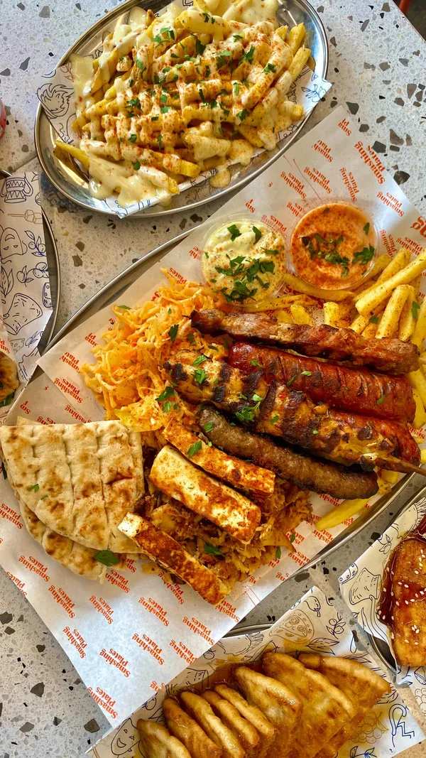 This video showcases a meal at Smashing Plates in London Bridge. The video highlights various Greek dishes, including a large grilled meat platter, gyros, halloumi fries, cheesy fries, and Pittanuts for dessert. The food is presented attractively and is shown being eaten by the influencer.  The video primarily focuses on promoting Smashing Plates restaurant and its menu.