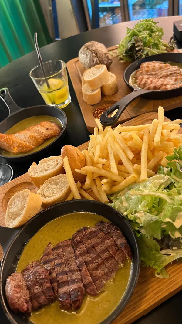 This video showcases Swiss Butter, a restaurant in Holborn, London. It features various dishes, including beef fillet, chicken, and salmon, each served with fries, salad, and bread with a signature butter sauce.  The presentation emphasizes the food's visual appeal, using close-ups and overhead shots.  The video also highlights the restaurant's ambiance and shows a family enjoying their meal. No specific dietary information is provided.