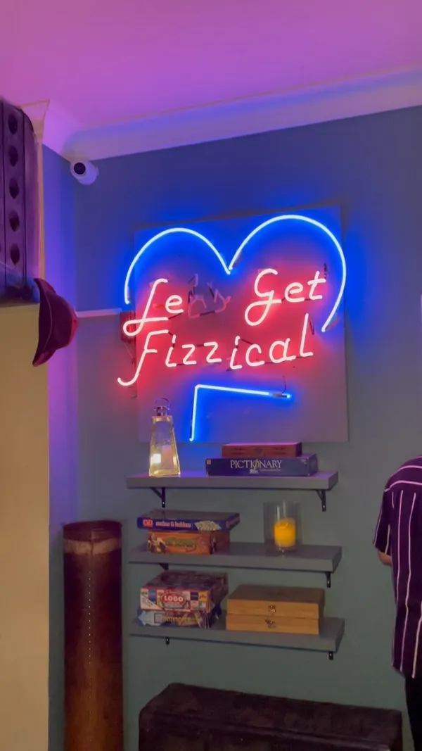 The video showcases a night out at The Little Blue Door in Fulham. It features various aspects of the bar, including the entrance, interior design, neon sign, food (burgers, fries, tacos), drinks (red wine), and a movie screening area. The presentation emphasizes a cozy, intimate atmosphere, with a focus on the food and drinks' visual appeal.