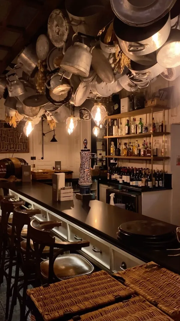 The video showcases a meal at Iberica restaurant in London, featuring a variety of tapas and other Spanish dishes.  The setting is a dimly lit, upscale restaurant with a stylish interior. Dishes shown include an artisan cheese and Iberian ham selection, pan con tomate, patatas bravas, serrano ham croquettes, pear and spinach salad, secreto Iberico pork with potatoes, black squid ink rice with prawns, and churros con chocolate.  The presentation is generally sophisticated, with dishes artfully arranged on plates.  No specific dietary information is provided, beyond the churros being marked as vegetarian. The main focus is showcasing the food and ambiance of the restaurant.