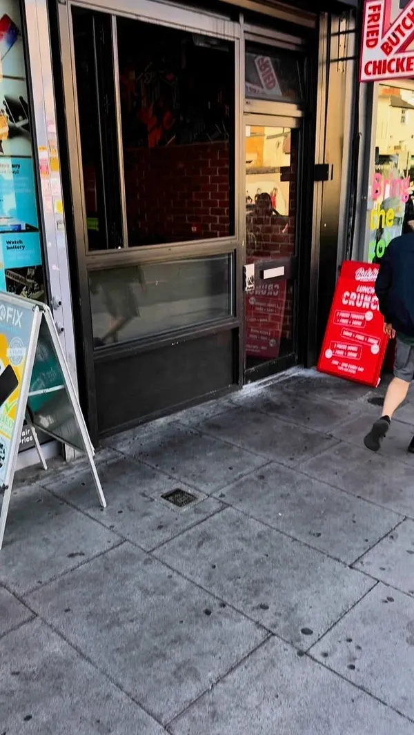 The video features the exterior of Butchies restaurant, followed by the influencer carrying a branded bag of food. He is then shown eating a fried chicken burger in a park. The video also includes close-ups of fried chicken tenders being drizzled with sauce and dipped in a white sauce.