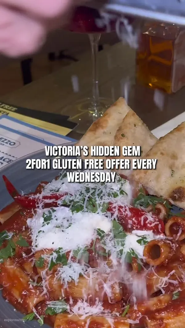 The video promotes an Italian restaurant, Prezzo, located in Victoria, London. It highlights a '2 for 1 gluten-free' offer available every Wednesday. The content showcases the restaurant's interior, followed by a variety of dishes including calamari, tomato bruschetta, a meat pizza, two different pasta dishes, and desserts like sticky toffee pudding and lemon meringue pie. The video also features drinks such as hot chocolate and cocktails/mocktails, with a focus on the appealing presentation of the food.