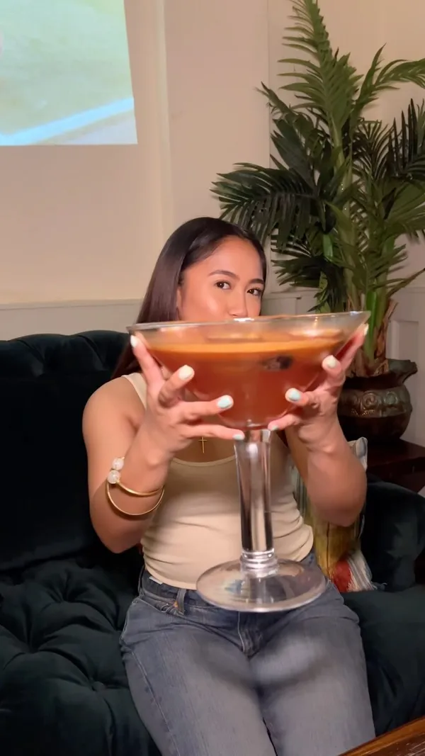 This video showcases The Little Blue Door, a bar in Fulham, London. It highlights their giant cocktails, specifically the 'Crimes of Passion' (strawberry & cream infused vodka, passion fruit, and fizz), and the 'Supersize Me!' sharing cocktail.  The video also shows other cocktails like the 'Diamonds are Forever', and depicts the bar's vibrant, eclectic interior and lively atmosphere. Three young women are the main focus, enjoying the cocktails and dancing.