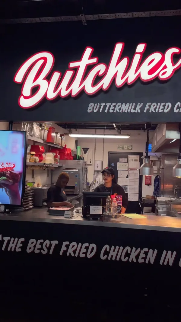 The video showcases Butchies, a fried chicken restaurant in Canary Wharf, London. It features various menu items, including fried chicken sandwiches, popcorn chicken, tenders, fries, and mac and cheese. The presentation emphasizes the crispy texture and juicy appearance of the food.  No specific dietary information is provided.