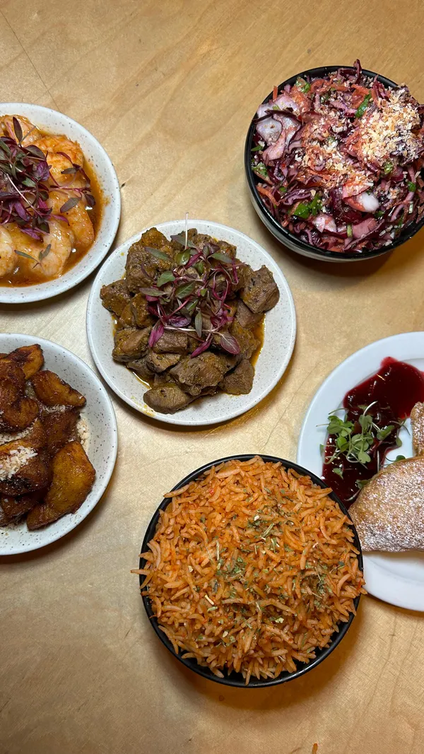 This video showcases Chuku's, a Nigerian tapas restaurant in Tottenham, London.  It highlights the restaurant's ambiance, featuring its pink walls and decor, along with a variety of dishes including various small plates of appetizers such as shrimp, plantain, and a red cabbage salad, and a dessert. The video emphasizes the restaurant's unique cultural experience and festive menu. 