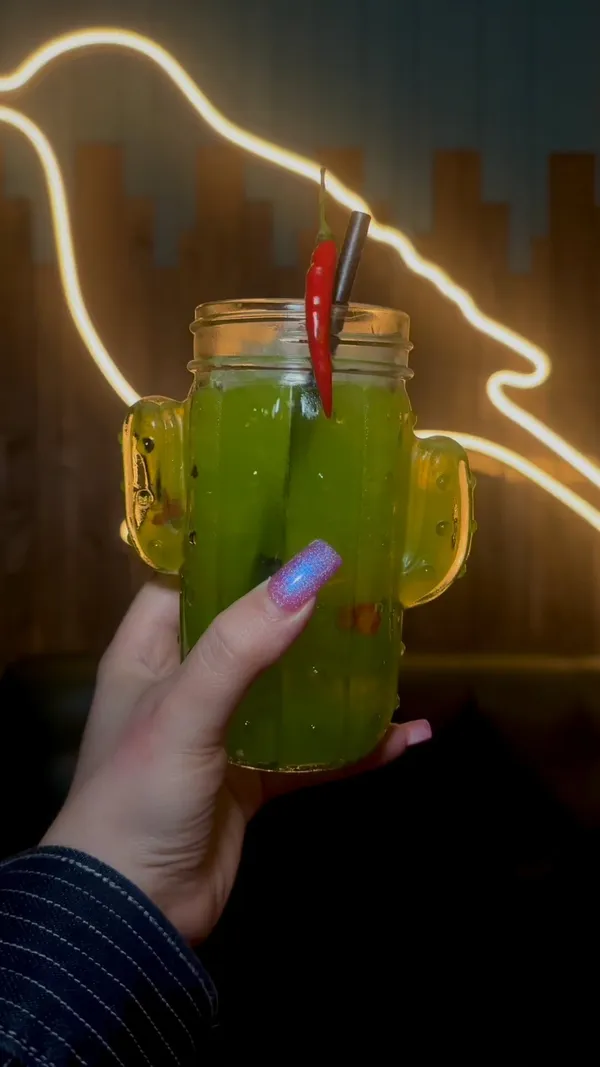 This TikTok video showcases Tequila Mockingbird, a chain of bars in London. It features various cocktails being prepared by bartenders, interspersed with shots of friends enjoying drinks and the bar's atmosphere.  The video highlights a January cocktail sale, with 2-4-1 deals and promotional pricing on wine, prosecco, beer, and shots.  The drinks include a green cocktail served in a cactus-shaped glass and a pink cocktail served in a tiki mug.  The overall tone is upbeat and celebratory. 