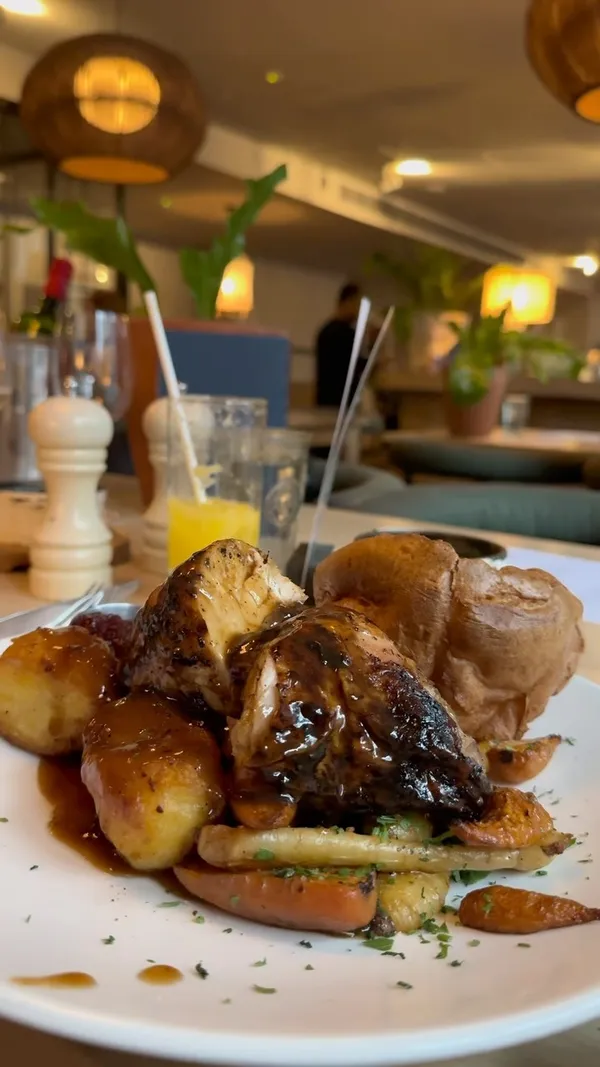 The video showcases a Sunday roast dinner at No35 Mackenzie Walk, a restaurant in Canary Wharf. It features various dishes, including a mixed roast (beef, pork belly, chicken), buttermilk fried chicken tenders, crispy squid, braised leek and cheddar croquettes, smoked aubergine and chickpea dip, and sticky toffee pudding.  The food is presented attractively, with close-up shots emphasizing textures and colors.  No specific dietary information is provided.