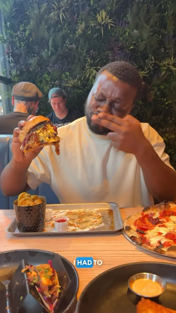 The video showcases Bat & Ball, a lively bar in Westfield Stratford City, London.  It features ping pong, darts, and karaoke. Food shown includes pepperoni pizza, chicken tenders, brisket tacos, and a 'Dirty Burger'.  The presentation focuses on close-ups of the food, highlighting textures and ingredients. No dietary information is explicitly mentioned. The main focus is on showcasing the food and the bar's entertainment options.