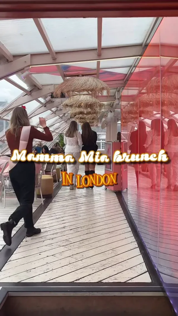 The video showcases a Mamma Mia-themed bottomless brunch event at Circe's Rooftop in Waterloo, London. It features the venue's decor, including straw umbrellas and mirrored walls, and shows guests enjoying drinks like prosecco and orange cocktails. Food items such as flatbreads topped with vegetables and fries are also displayed. The video highlights entertainment, including performers singing ABBA songs and a drag queen act. Guests are shown dancing and enjoying the event.