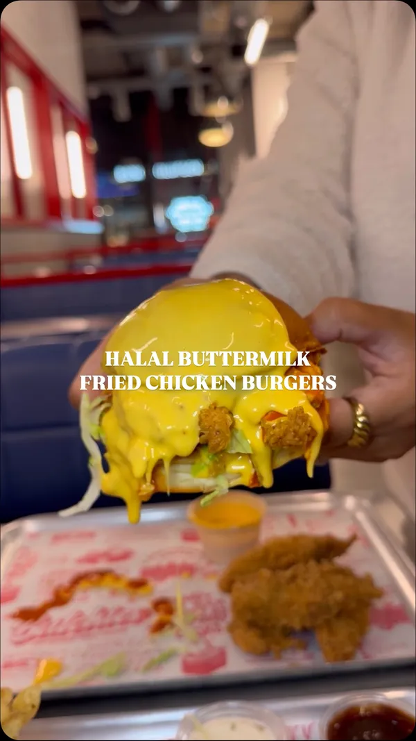 The video showcases halal crispy and juicy buttermilk chicken burgers from Butchies in Ealing, London. The setting is inside the restaurant, featuring the preparation and presentation of the food. The video highlights the cheesy rider burger with fried chicken, pickles, buffalo sauce, and cheese sauce, as well as chicken tenders dipped in cheese sauce and mac and cheese. The main focus is on the food's visual appeal and taste.