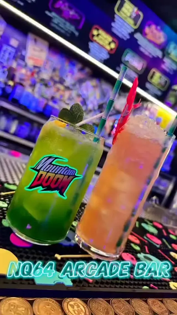 This video showcases NQ64 Arcade Bar in Cardiff. It highlights the bar's neon aesthetic, game-themed cocktails (Mountain Doom and Aku Aku Fruit Punch), and selection of arcade games.  The main focus is on the overall experience of visiting the bar, combining gaming and cocktails.