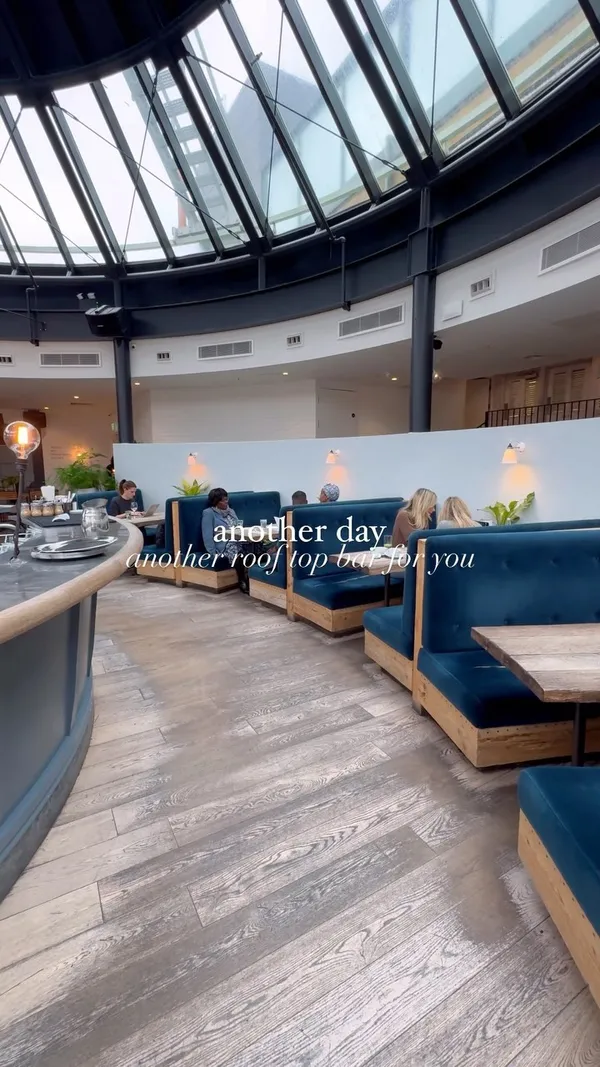 The video showcases The Address, a rooftop bar in Wimbledon. It features various food and drink items, including chicken wings, a burger, a steak sandwich, mac and cheese, cocktails, and bottomless drinks. The presentation is visually appealing, with well-lit and nicely arranged food and drinks. No dietary information is explicitly provided. The main focus is on showcasing the venue's ambiance and menu items.