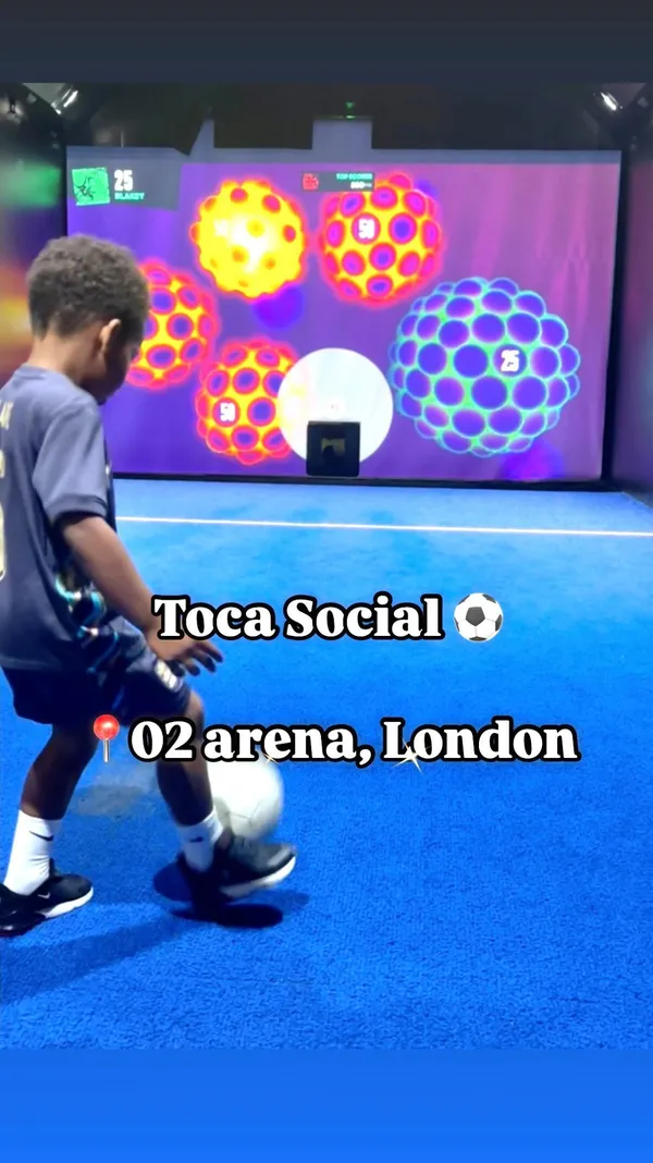 The video showcases Toca Social, a venue at The O2 London that combines football games with dining.  It features a variety of interactive football games suitable for different ages. Food shown includes buffalo wings, cheeseburger sliders, and other items from the main menu and 'Little Ballers' kids menu. The presentation emphasizes the fun and energetic atmosphere, highlighting various food and game options.  A kids menu with options from £10 is mentioned.