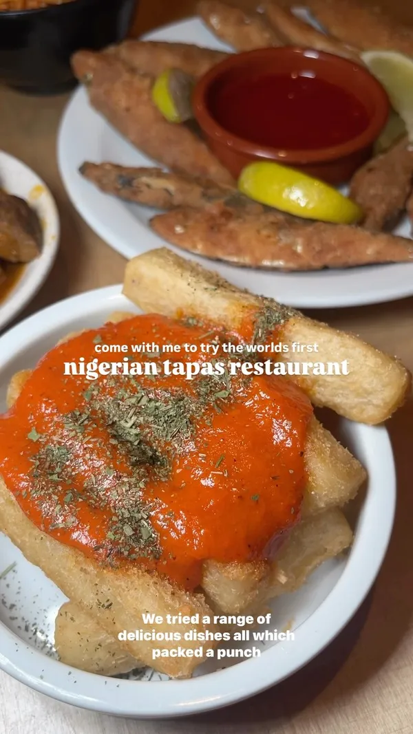 The video showcases Chuku's Nigerian tapas restaurant in Tottenham, London. It features various dishes, including kuli kuli wings, spicy fried whitebait, cassava fries with a spicy sauce, suya prawns, and a plantain waffle with ice cream and blueberries. The drinks shown include a Chapman punch. The video highlights the restaurant's ambiance and food presentation, emphasizing the bold flavors and generous portions.