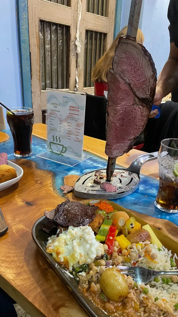 This video reviews Preto Restaurant, a Brazilian steakhouse in London's West End. It showcases the restaurant's rodizio grill, featuring a variety of grilled meats served table-side, along with an extensive salad bar offering various hot and cold dishes, including salads, pasta bakes, and fried bananas. The video highlights the unlimited meat option and the abundance of food available. Dietary information is not explicitly mentioned. The main focus is on the food, the dining experience, and the overall value for money. 