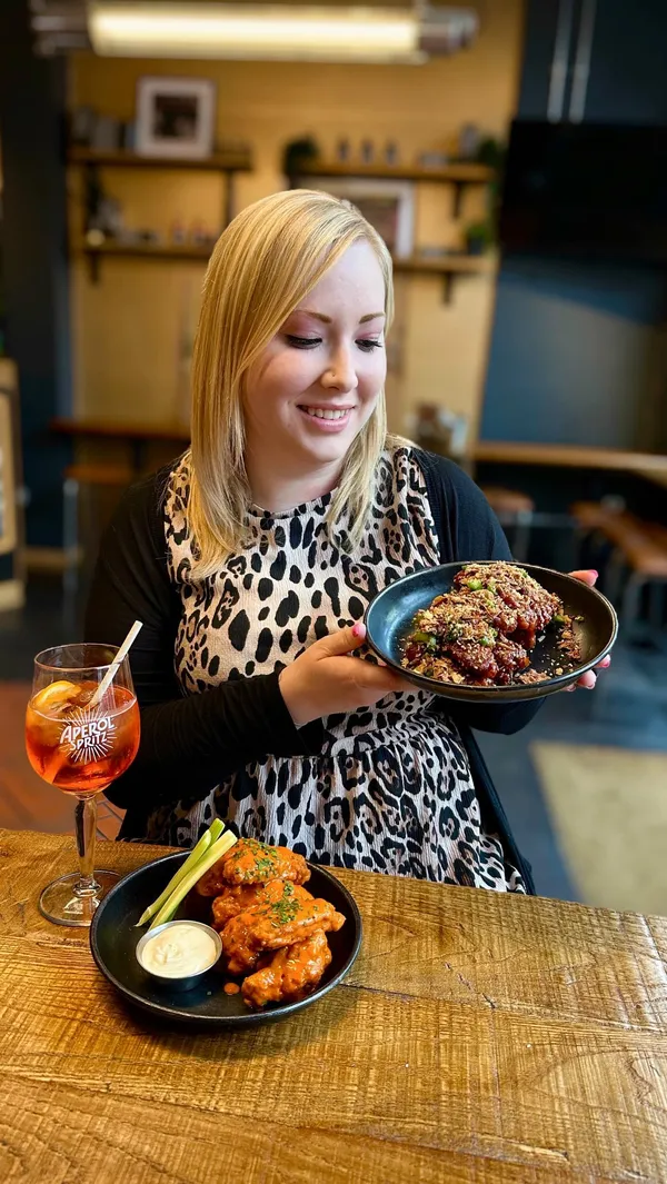 The video showcases Wingman's Bottomless Brunch in a London restaurant. It features various shots of the food (buffalo wings, sweet and smokey BBQ wings, Shanghai Oriental wings, and Bang Coq wings), bottomless fries, and bottomless drinks (Aperol Spritz, among others).  The presentation focuses on the vibrant colors and textures of the dishes. No specific dietary information is given. The main focus is on the food and the enjoyable brunch experience.