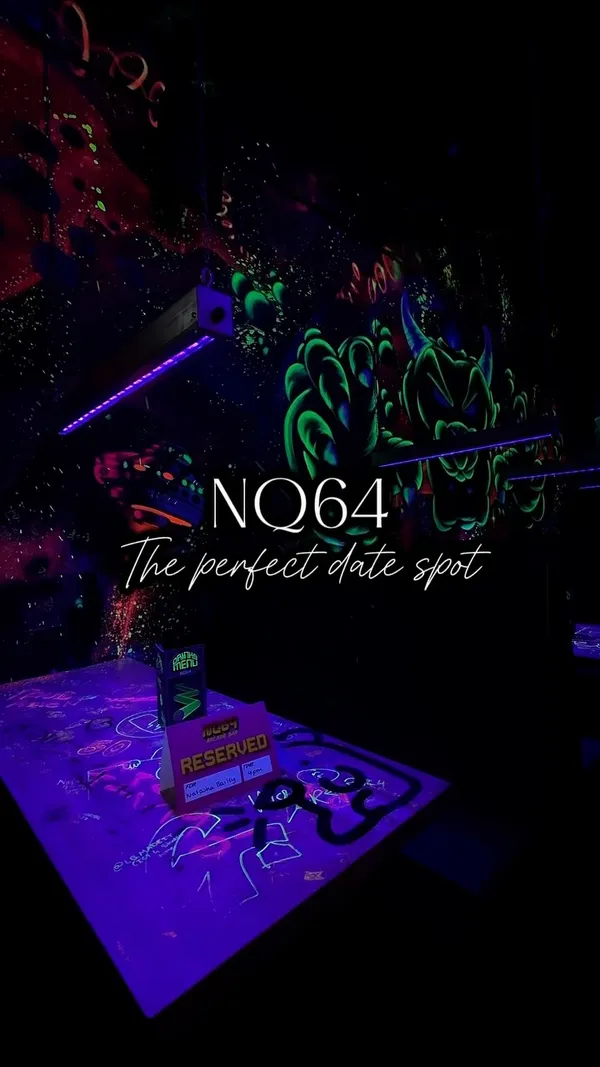 The video showcases NQ64 Arcade Bar in Digbeth, Birmingham. It features a tour of various arcade games and consoles available, including classics like Pac-Man, Tekken 2, Mortal Kombat, Dance Dance Revolution, and consoles such as SNES, Xbox, Playstation, and Nintendo 64. The video emphasizes the nostalgic experience of playing these games, suitable for friends, couples, and families.  No food or drinks are explicitly shown, though the drinks menu is briefly visible. The atmosphere is dark, with neon lighting enhancing the arcade setting.