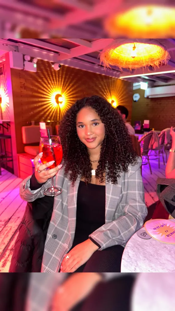 The video is set at Circe's rooftop bar. It features a woman posing with various food items, including fried calamari with a lemon wedge, flatbread with a red topping, and another dish with a tomato-based topping. The presentation focuses on the food and the rooftop ambiance. No dietary information is explicitly mentioned. The main focus is on showcasing the food and the bar's atmosphere.