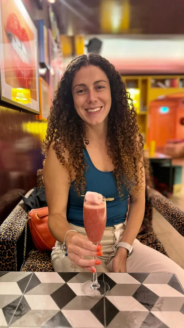 The video showcases The Little Violet Door, a bar in Soho, London.  It features various cocktails (including one served in a can), bar snacks like a chicken sandwich and fries, and glimpses of the bar's interior, which is eclectic and vibrant. The presentation emphasizes the fun and lively atmosphere. No dietary information is explicitly provided.