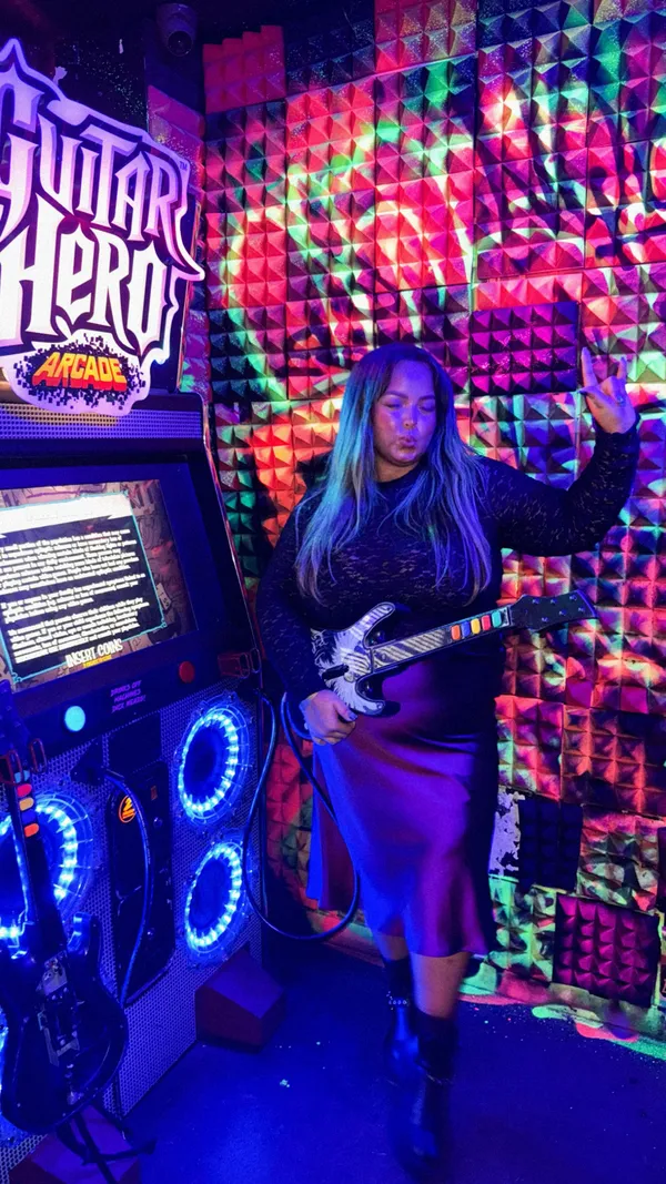 The video showcases NQ64, a retro arcade bar in Soho, London. It features various classic arcade games like Pac-Man, Mortal Combat, Dance Dance Revolution, and Guitar Hero.  The bar serves creative cocktails, including the Kong Island Iced Tea. The video highlights the bar's neon lighting, energetic atmosphere, and overall fun experience.  Two women are shown enjoying the games and drinks throughout.