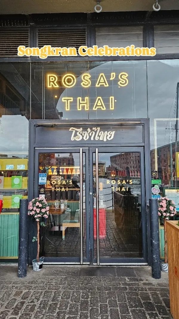 The video showcases Rosa's Thai restaurant, featuring its exterior, interior, and several food and drink items. The food includes Thai fried chicken, okra tempura, sweetcorn fritters, and vegetable spring rolls, all served with sweet chilli sauce. Drinks shown are a yellow bubble tea (Jasmine) and a chocolate bubble tea with whipped cream. The video highlights a special "Songkran Spirit" menu.