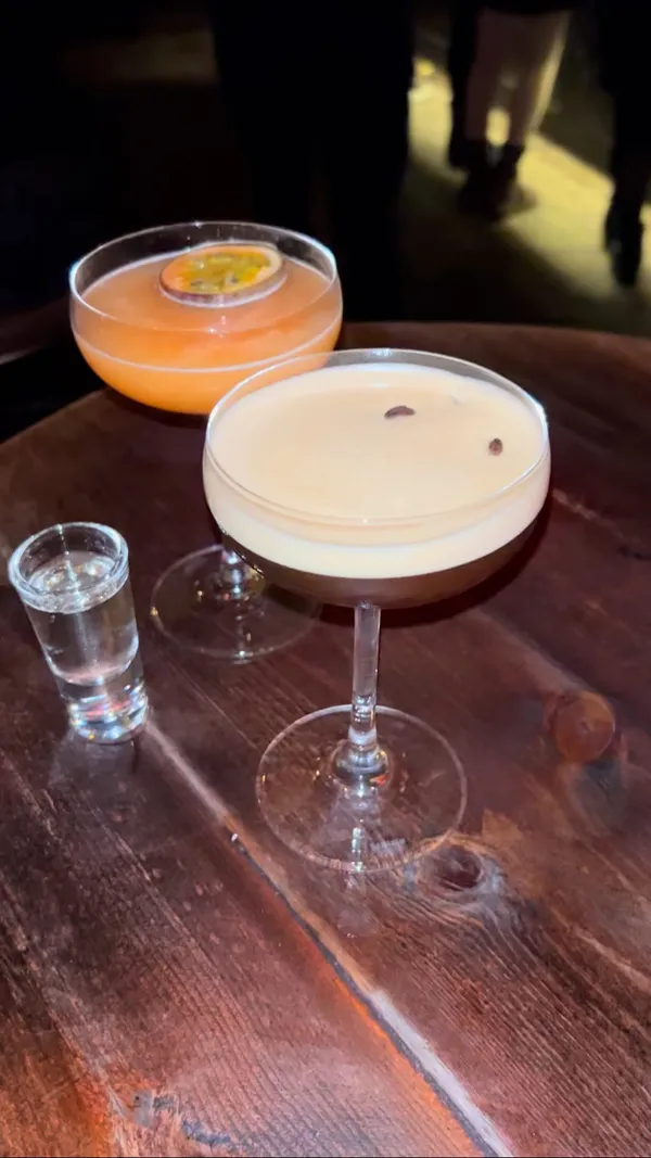 The video showcases a variety of cocktails at what appears to be a trendy bar.  Cocktails include a passionfruit-topped martini, an espresso martini, a pink cocktail with a gummy candy garnish, and an Aperol Spritz.  The drinks are presented in attractive glassware, with garnishes and layered appearances.  The video focuses on the cocktails and the bar's atmosphere, but does not provide dietary information. The main focus is on the cocktails and the bar’s ambiance.