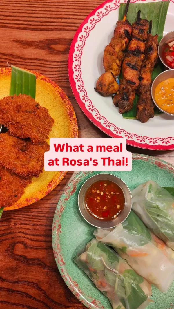 The video showcases a visit to Rosa's Thai restaurant in Norwich. It begins with an exterior shot, moves inside showing the decor, highlights drinks (Thai Milk Coffee, Passion Fruit Iced Tea), appetizers (pumpkin crackers with dip, summer rolls, chicken satay, prawn doughnuts), and main courses (Tom Yum Noodle Soup, Gaeng Panang Curry with rice). It also briefly shows a child playing with an origami elephant menu feature. The focus is on presenting the variety and visual appeal of the food and the restaurant's ambiance.