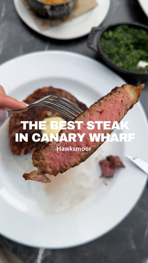This video showcases a meal at Hawksmoor steakhouse in Canary Wharf, London.  The food presented includes a ribeye steak (cooked medium-rare), peppercorn sauce, fillet steak with beef jus, various starters, cocktails, and a chocolate dessert. The presentation emphasizes the quality and visual appeal of each dish, with close-up shots highlighting textures and details. No dietary information is explicitly stated.