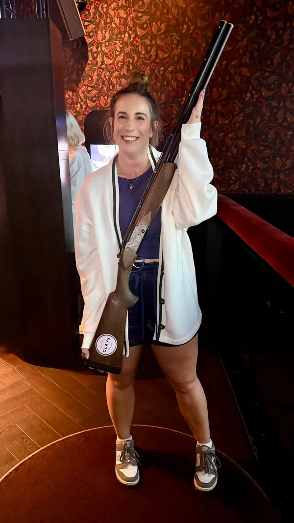 The creator visits Clays in Canary Wharf for a summer party event, showcasing the clay pigeon shooting simulator game 'Surf's Up', the venue's atmosphere, and a selection of food and drinks including truffle fries, sweetcorn ribs, and chocolate brownies.