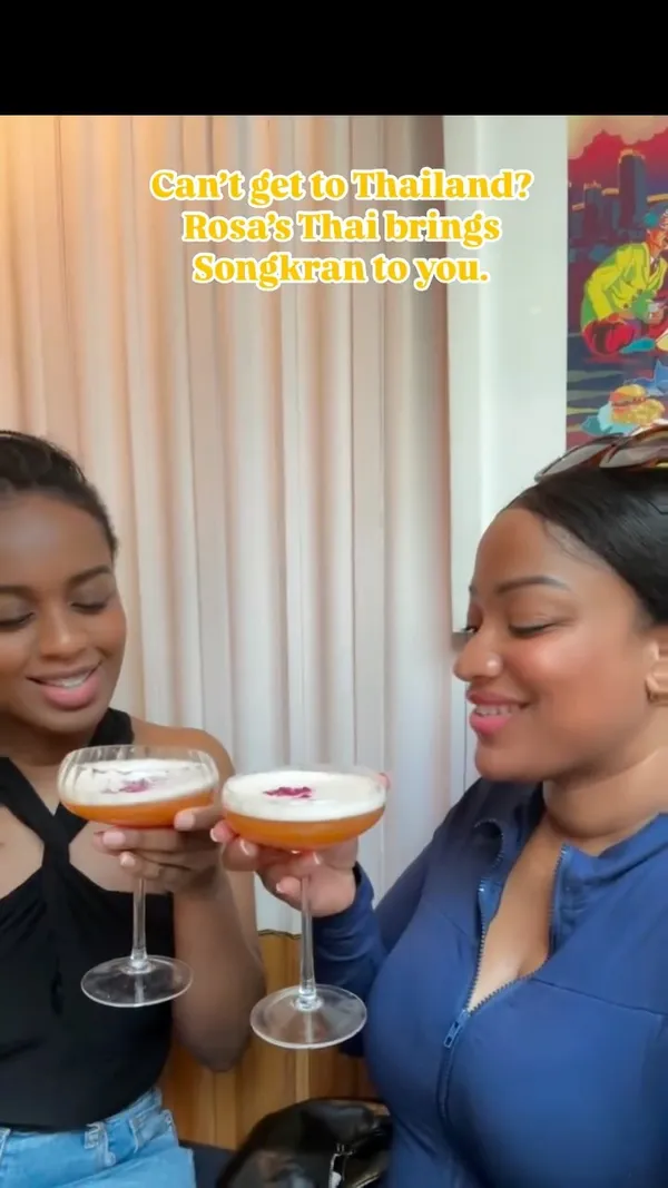 The video promotes Rosa's Thai restaurant's Songkran special menu. It features a close-up of a hand dipping food from a sharing platter, shots of the restaurant exterior and interior, a cocktail being poured and two people drinking cocktails, various close-ups of the sharing platter items (prawn crackers, spring rolls, skewers, fried items with dips), and a plate of Pad Thai with shrimp and peanuts. Text overlay highlights the Songkran theme.