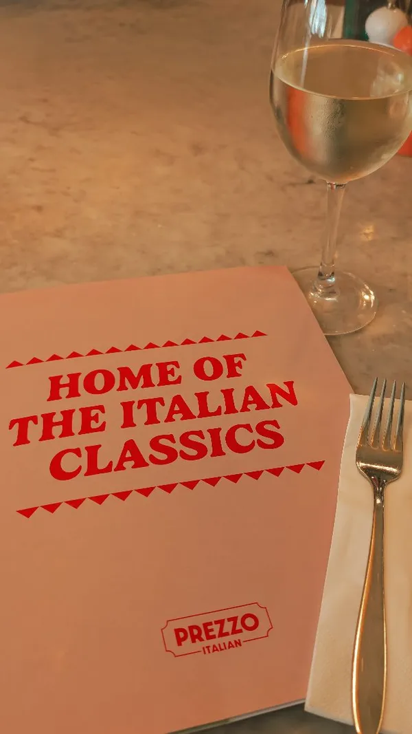 The video documents a family's visit to a Prezzo Italian restaurant. It begins with an exterior shot, followed by views of the stylish, well-lit interior. The content showcases a young child colouring and the family enjoying various dishes, including garlic bread, smoked salmon bruschetta, mozzarella sticks, pappardelle, rigatoni, and spaghetti bolognese. The meal concludes with desserts: a lemon meringue pie and a chocolate skillet cookie with ice cream. The overall theme is a positive, relaxed family dining experience.