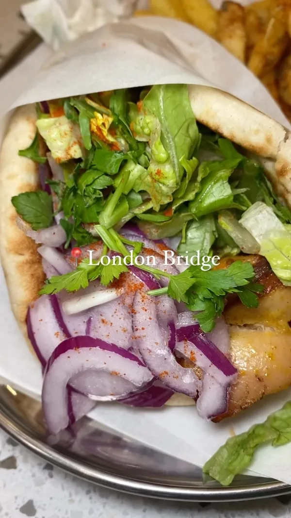 The video showcases a meal at Smashing Plates, a restaurant in London Bridge.  The food includes a gyro, fries, vegan nuggets, halloumi fries, and a brownie. The presentation is simple, focusing on the food itself.  Vegan options are shown. The main focus is on the influencer enjoying a meal.