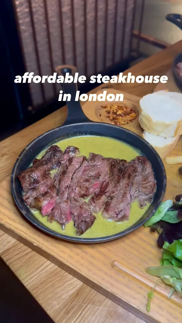 The video showcases a meal at Swiss Butter in Holborn, London. The main focus is on the food, specifically a steak platter (£19) with options for fillet or ribeye, along with salmon or chicken alternatives.  The platter includes fries, bread slices, and a house salad. The video also shows pain perdu and molten chocolate desserts. The setting is a modern, dimly-lit restaurant. The presentation emphasizes close-ups of food items and their textures.